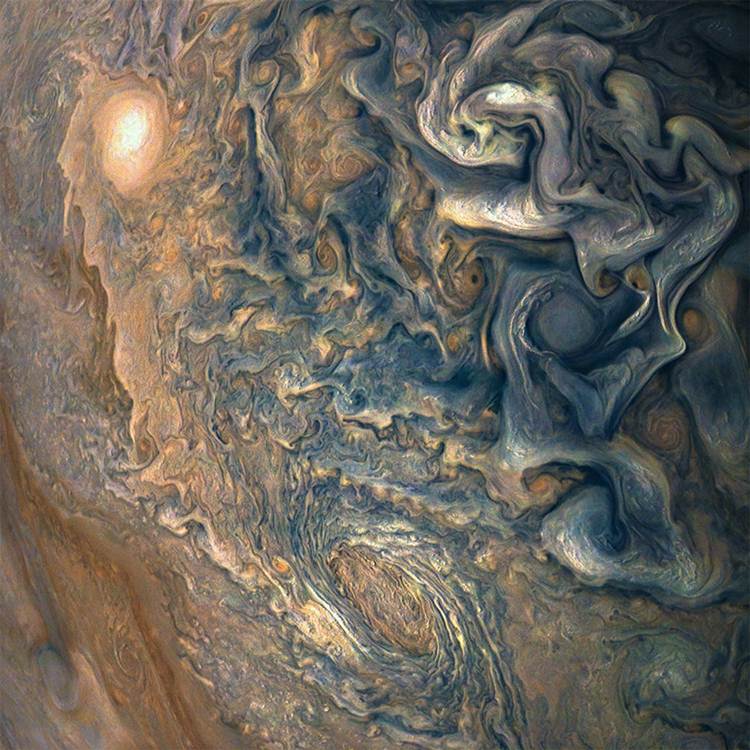 在画面中，木星表面像是交叉的白色缎带，是木星低纬度地区最大的顺时针旋转气旋。