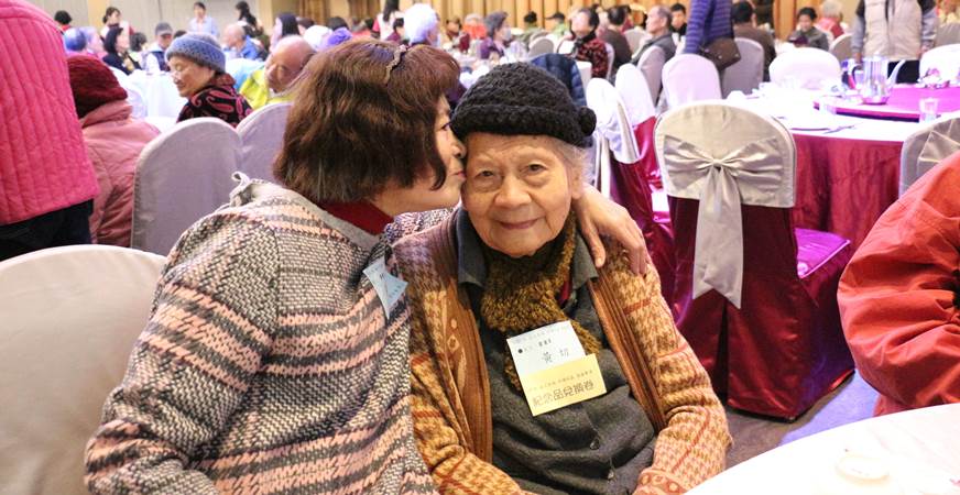 65歲的黃淑嬌(左)陪伴94歲的母親黃切參與市居服圍爐活動