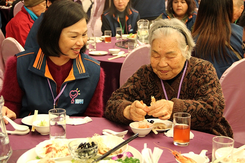 围炉餐会上，年纪最长的九十四岁杨奶奶享受丰盛的菜餚。