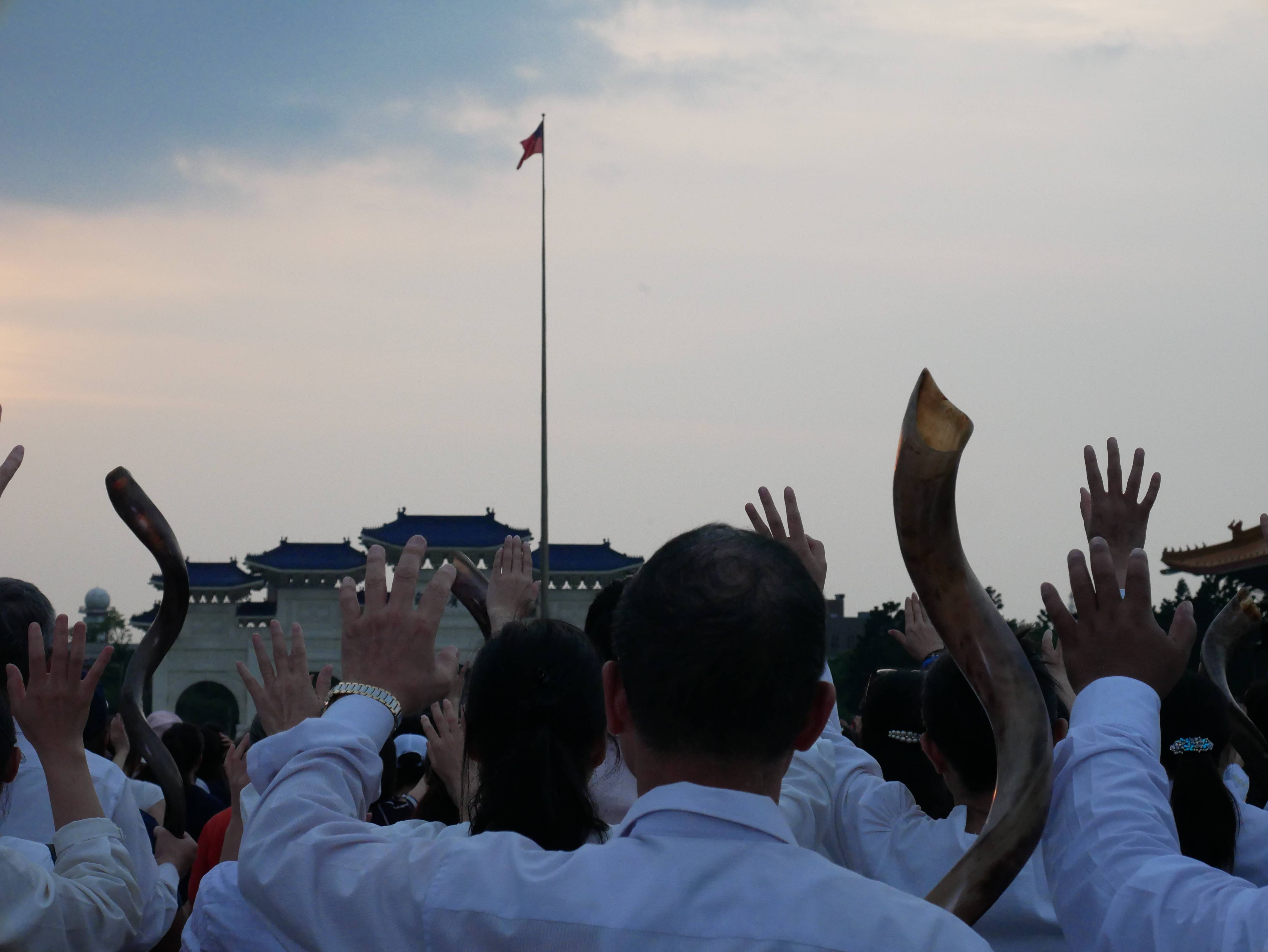 眾弟兄姊妹在降旗典禮進行時舉手為國家禱告。